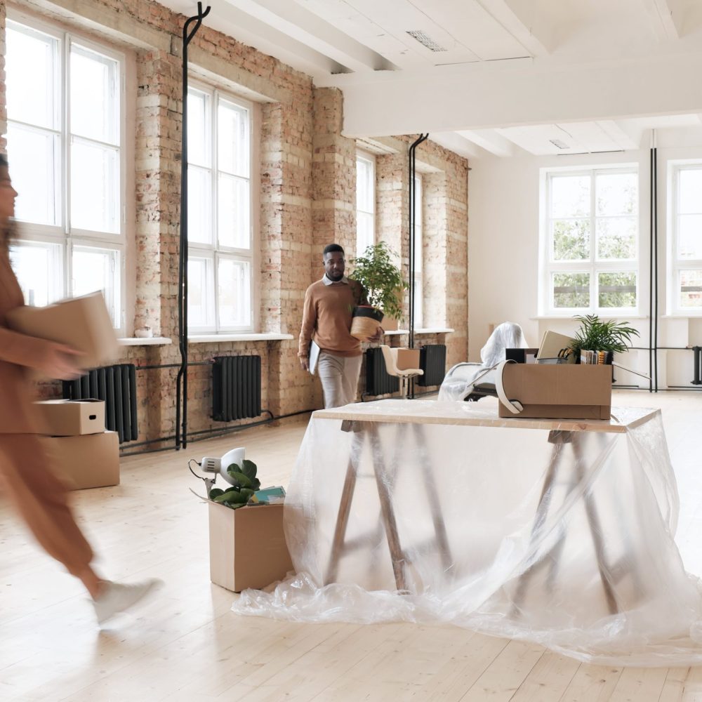 young-multiethnic-employees-loader-carrying-stuff-table-polyethylene-while-preparing-new-office-before-opening-min